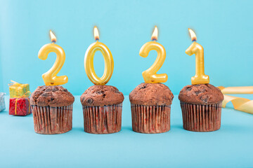 2021 Number gold candle on a cupcake against a pastel blue background two thousand and twenty one year celebration