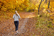 © alfa27 - female running jogging in the forest, wearing sport clothes, at sunny autumn weather. sport, workout, run, wellbeing concept. rear view