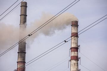 Smoke from two industrial chimneys, pipes, against the sky. Global warming. Air pollution. Ecological pollution. Air emissions polluting the city. Industrial waste is hazardous to health.