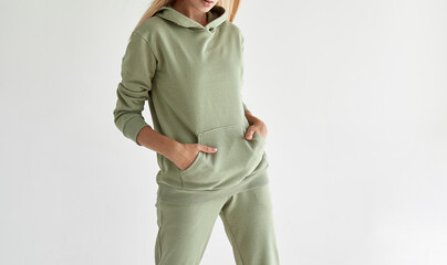 Wall Mural - girl wears light green hoodie and pants. studio shot for sport clothing sale