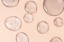 Drops And Smears Of Cosmetics. Drops Of Liquid Transparent Gel With Bubbles On A Brown Background.