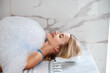 Pretty female enjoying spa procedure with soap foam in beauty center