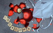Zerbrochene rote Weihnachtskugeln, FFP 2-Maske und LOCKDOWN in Buchstaben