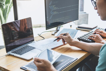 Writing codes and typing data code technology, Programmer cooperating working on web site project in a software developing on desktop computer at company, Programming with HTML, PHP and javascript