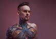 © Fxquadro - Shirtless and bearded bearded and tattooed guy with stylish hairstyle and sunglasses poses in colourful background with lights.