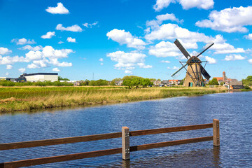 Wall Mural - Famous windmills in Kinderdijk village in Netherlands. Colorful spring rural landscape with windmill and river. UNESCO World Heritage and famous tourist site.