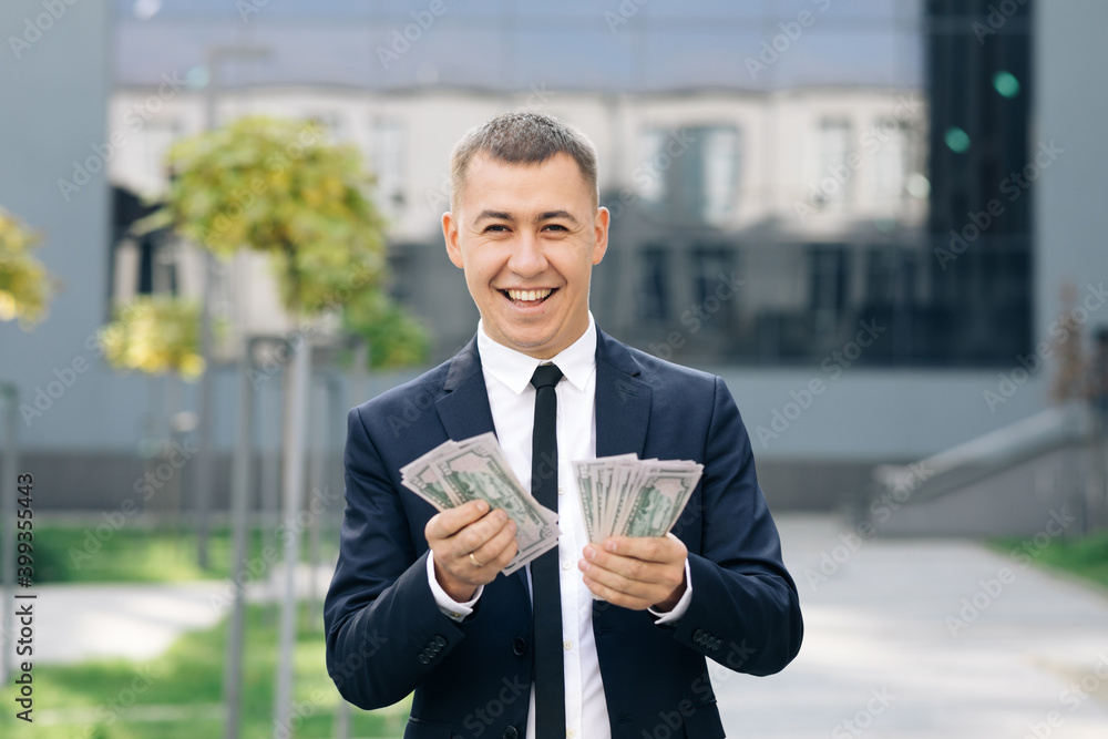 Successful businessman enjoying financial success and counting money