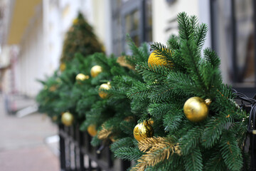 Wall Mural - Fence decorated with pine branches and golden balls. Christmas tree decoration