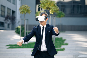 Cheerful young gamer in virtual reality goggles is expressing excitement while enjoying car racing video game. Man playing racing games using vr headset. Man wearing VR glasses watch Driver POV.