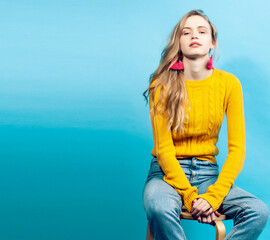 young pretty teenage modern hipster girl posing emotional happy on blue background, lifestyle people