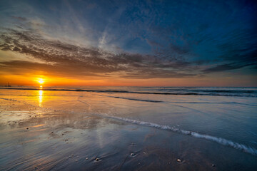 Spectacularly colored sunset with a beautiful reflection in the sea water