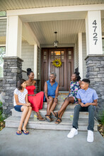 Portrait Of Family Sitting On Front Porch Steps