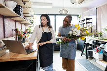 Coworkers At Florist Startup Shop Checking Online Orders On Laptop