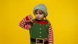 © Andrii Iemelianenko - Displesed blonde kid teen girl in Christmas elf Santa helper costume doesnt agree with ideas how to celebrate New Year keeps thumbs down, dislike gesture