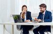© SHOTPRIME STUDIO - Business man and pretty woman in a suit at work In the office with an open laptop and a flower in a pot