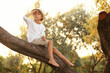 © New Africa - Cute little boy on tree outdoors. Child spending time in nature