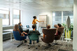 © David Prado/Stocksy - Group of business partners listening to presentation with flip chart at office