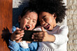 © Santi Nunez/Stocksy - Afro and asian children taking a selfie.