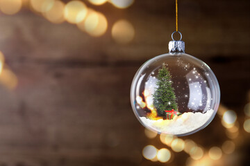 Wall Mural - Beautiful glass ball with Christmas tree and gift on blurred background, space for text. Bokeh effect