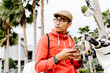 © Santi Nunez/Stocksy - Stock photo of asian guy texting mobile phone in the city. He is sending a message.