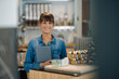 © KNSY/Westend61 - Happy female owner holding digital tablet standing in coffee shop