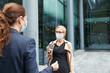 © PETE  MULLER/Westend61 - Women wearing face mask while talking against office building