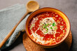 Bowl of homemade creamy roasted tomato soup with fresh herbs and parmesan cheese.Ketogenic low carb diet.Plant-based vegan meal recipe.Vegetable soup appetizer.Mediterranean dieting dinner