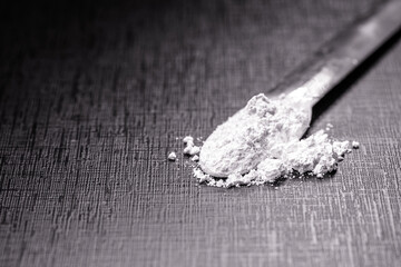 spatula with small portion of calcium carbonate, isolated black background