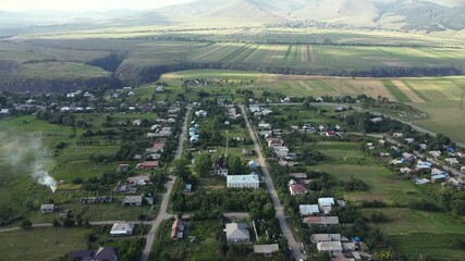 Wall Mural - Aerial view of Farmlands and Mountains, slow pull back pan