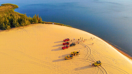 Aerial view of Bau Trang lake (raw of automobiles with blue sky in desert, beautiful landscape of white sand dunes), the popular tourist attraction place in Mui Ne, Vietnam.