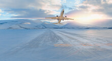 Passenger Airplane Fly Up Over Take-off Runway Snowy Mountains In The Background - Snow-covered Airport At Sunset