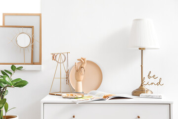 Wooden hand with female jewelry on chest of drawers in interior of room