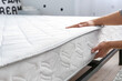 © Pixel-Shot - Woman putting soft orthopedic mattress on bed