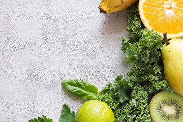 Wall Mural - Green vegetables and fruits on concrete background, ingredients for smoothie