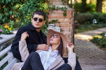 Young international couple in love sitting on a Park bench