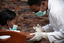 African Doctor Injecting An African Woman With A Vaccine For Covid 19