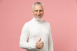 © ViDi Studio - Smiling cheerful elderly gray-haired mustache bearded man wearing casual basic white turtleneck standing showing thumb up looking camera isolated on pastel pink color wall background studio portrait.