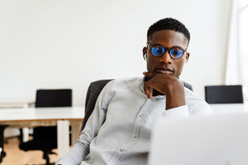 Poster - Afro american serious man in earphones working with laptop