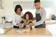© goodluz - Family in home kitchen baking american cookies
