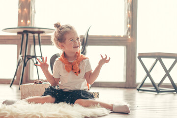 little girl playing sitting on the carpet in the living room