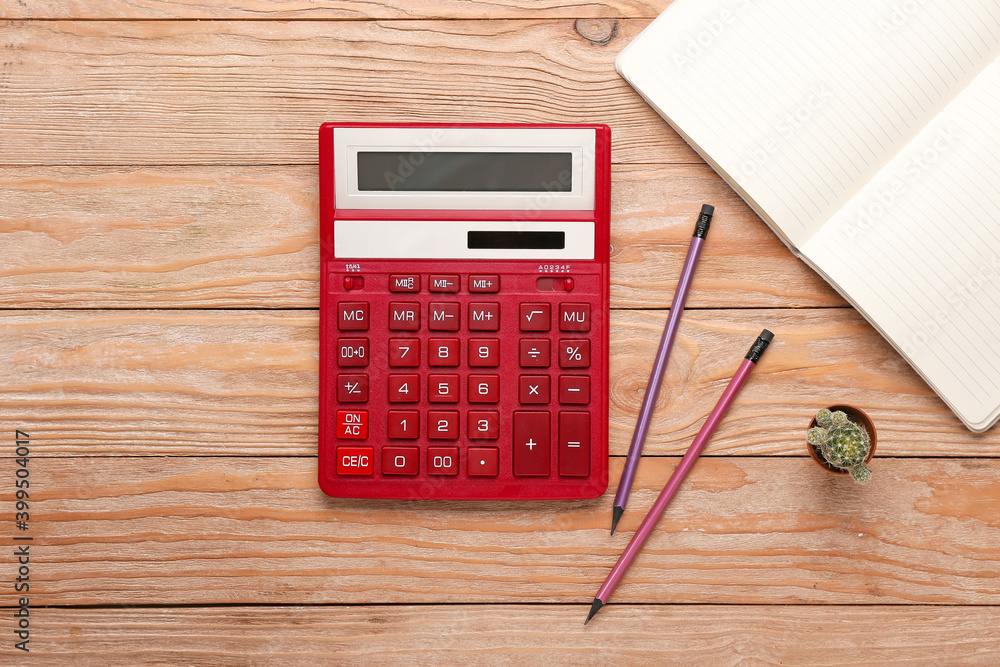 Modern calculator and stationery on wooden background