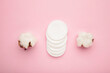 Hygienic disposable product cosmetic pads and cotton flower on pink background.