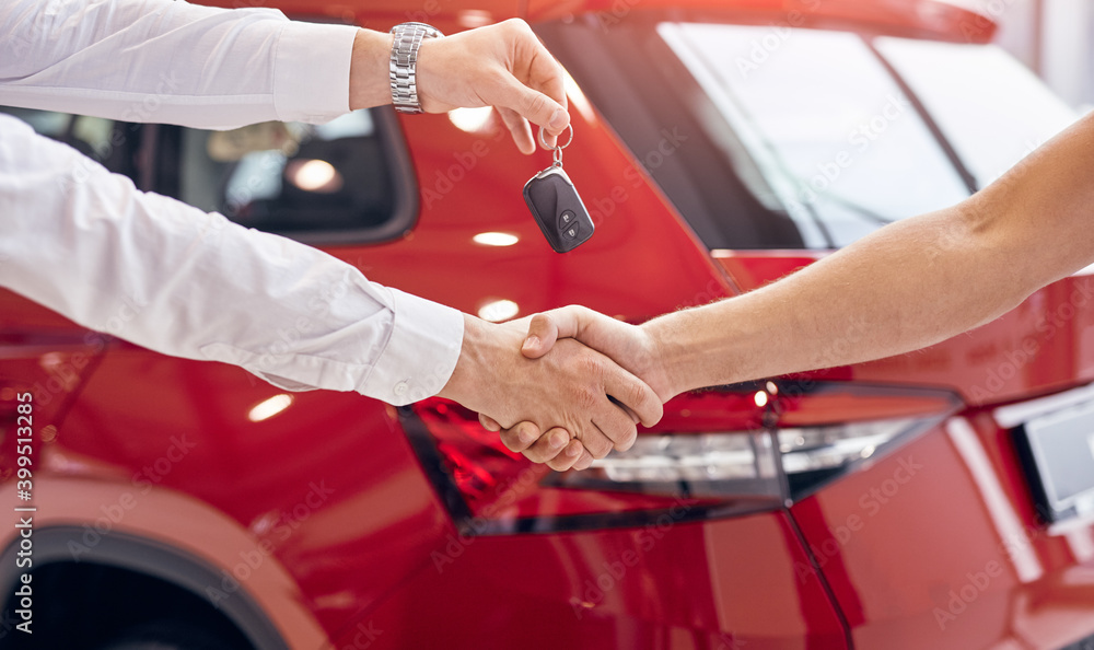 Crop dealer with car keys shaking hand of client - obrazy, fototapety, plakaty 