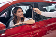 © kegfire - Happy woman buying new car in salon