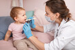 © Dmitry Naumov - Pediatrician checking sore throat of baby girl at home during coronavirus lockdown