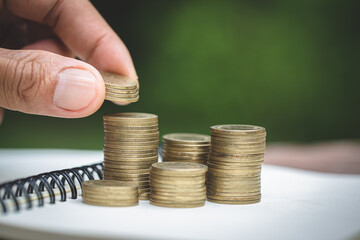 Wall Mural - Human hand  putting coins money stack step growing growth saving money, deposit Close up of person hand stacking golden coins, Concept finance business investment.