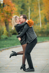 Young lovers hug and smile in the Park in autumn