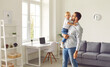 © Studio Romantic - Young dad holding his happy little son standing in cozy room of their new apartment