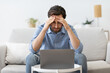 © Prostock-studio - Businessman At Laptop Touching Head Having Business Problem Sitting Indoors