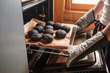 Failed Cooking In Oven. Woman Holding A Tray Of Spoiled Muffins